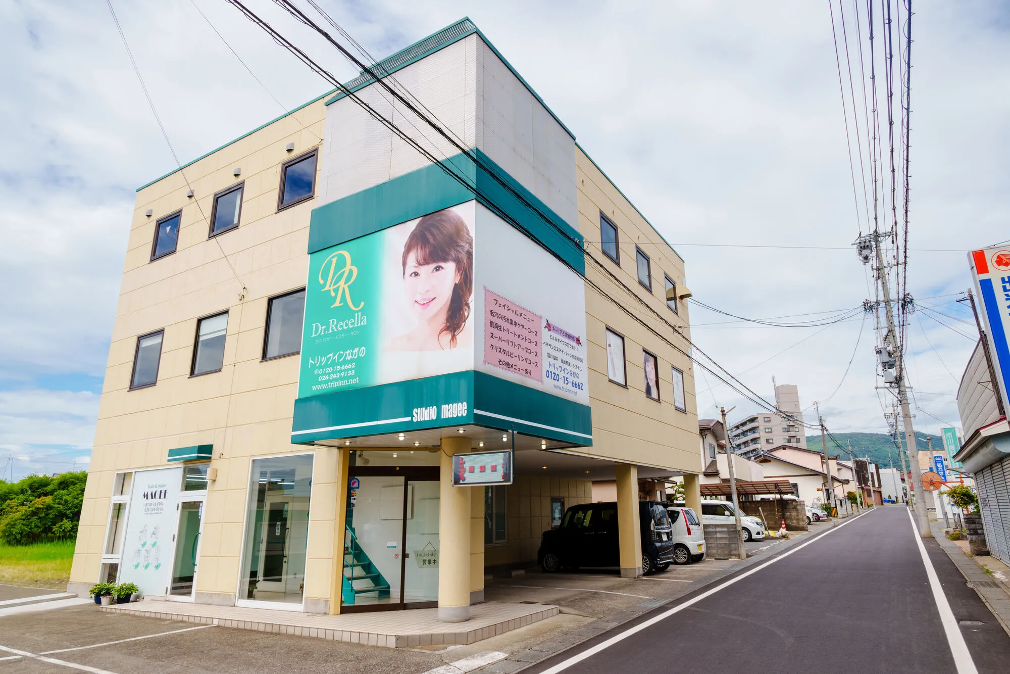 トリップインながの ＆ MAGEE の店舗外観（クリーム色の3階建てビル1階）